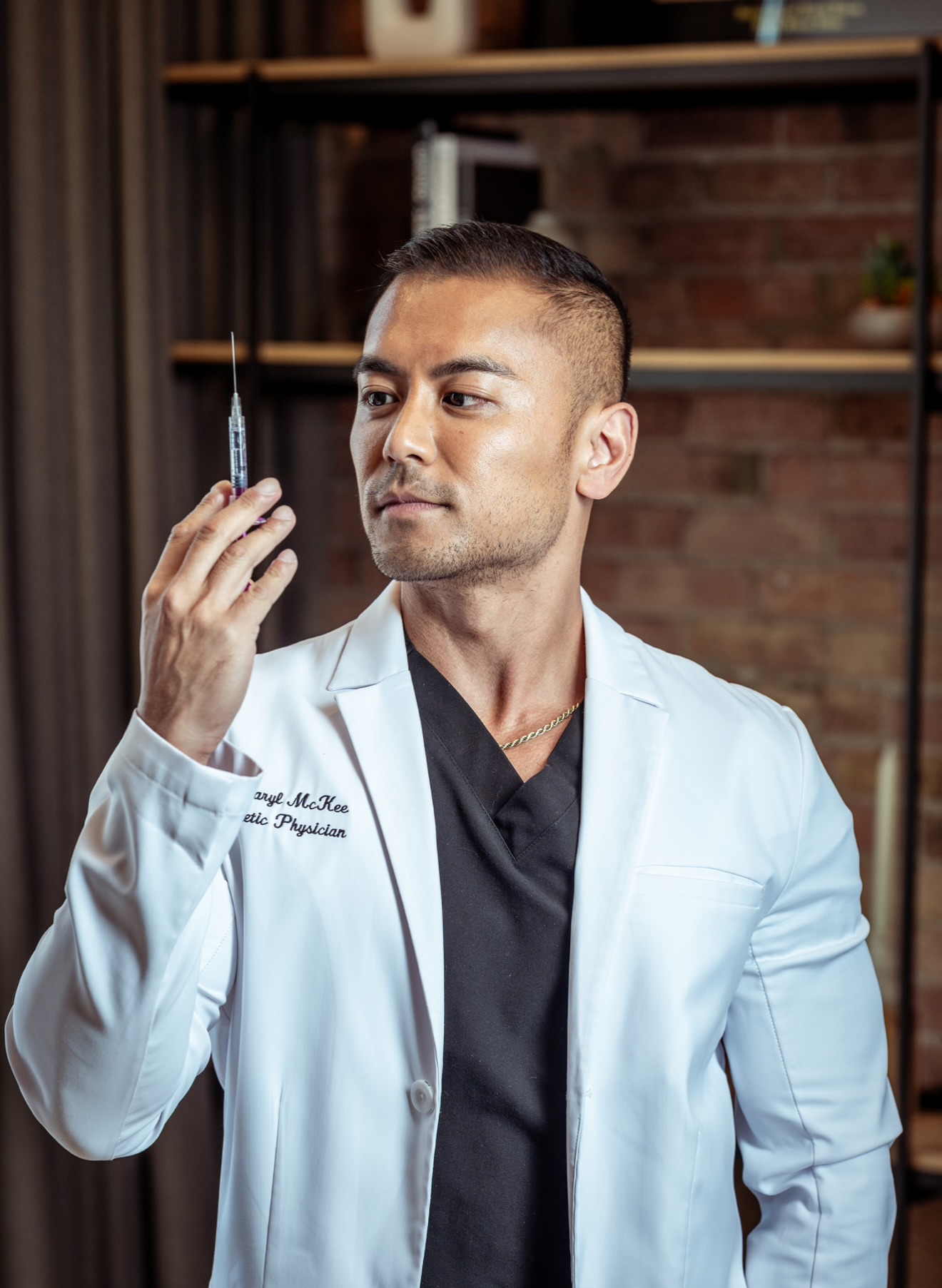 Dr. McKee in a white coat examining a syringe